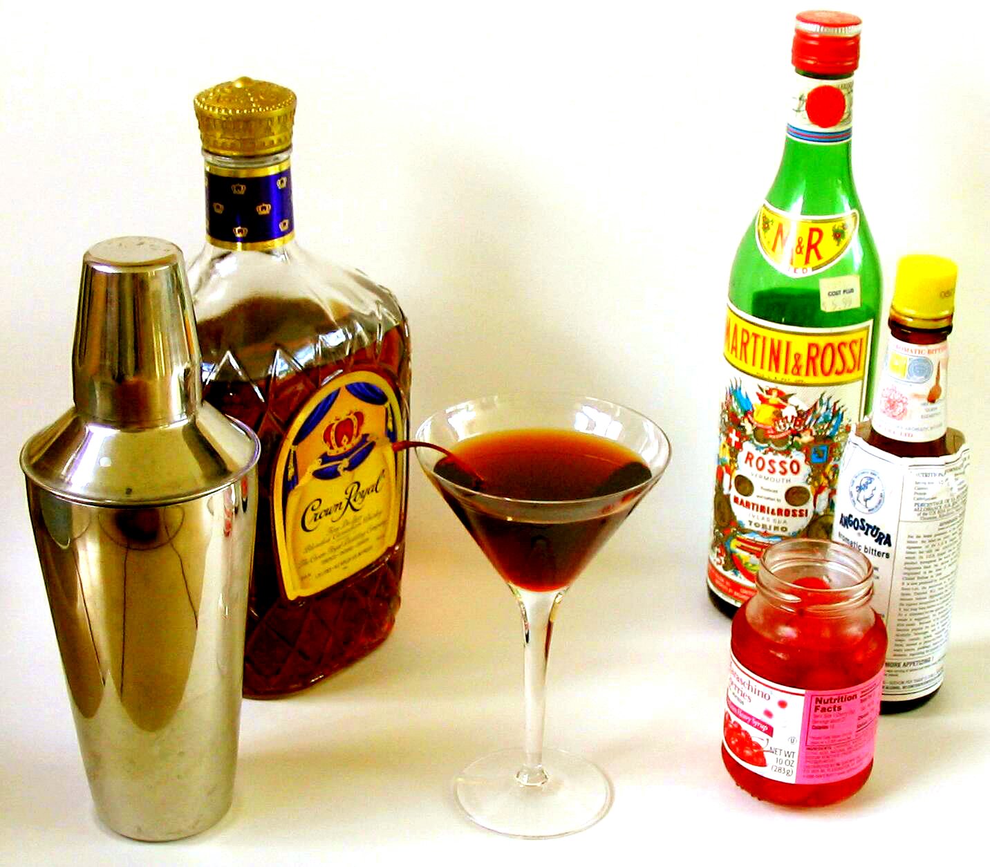 Коктейль Manhattan с бутылкой Angostura bitters, виски и вермутом