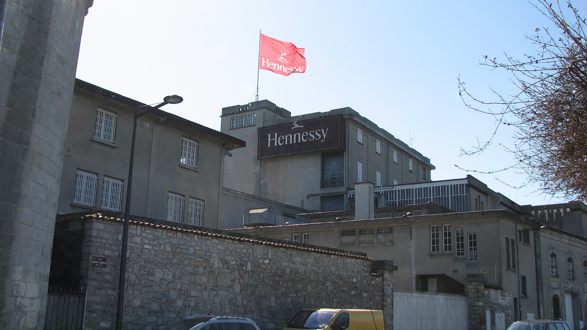 Панорама погребов Hennessy в Коньяке с флагами компании