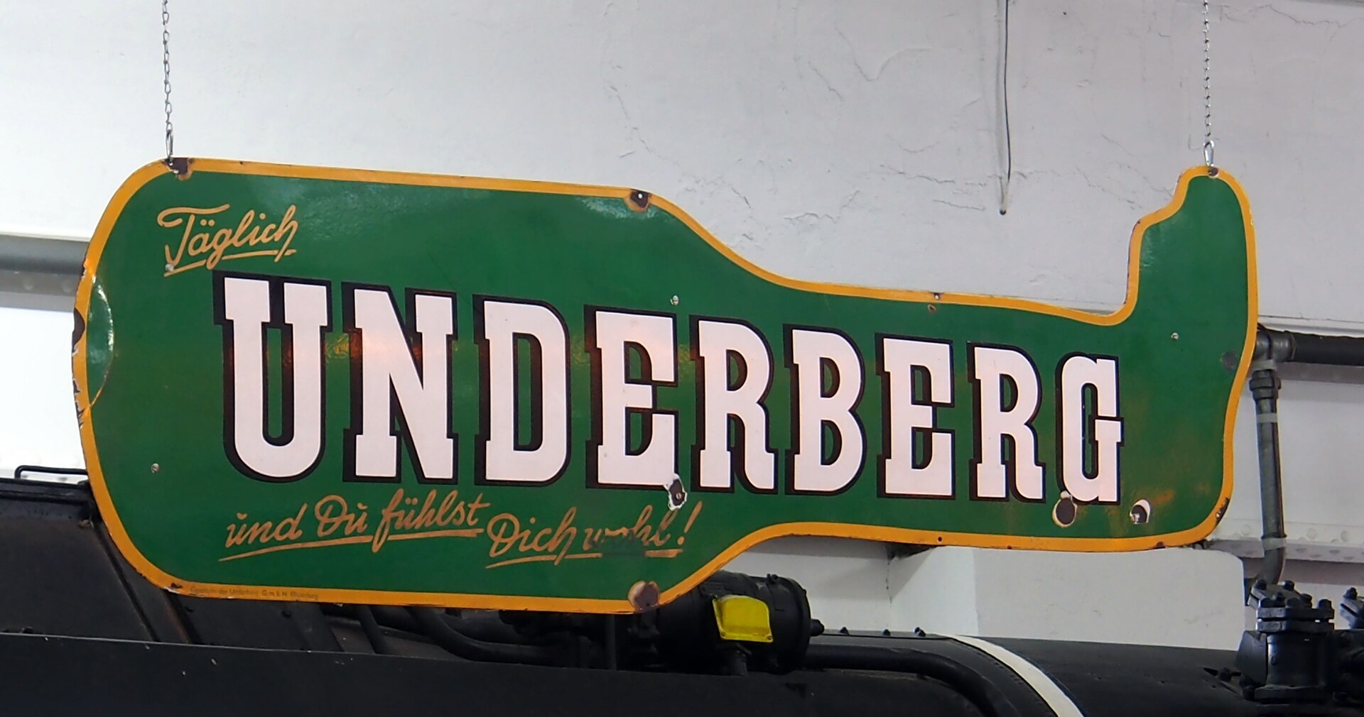 Старая эмалированная реклама Underberg в форме бутылки: «Täglich Underberg — und Du fühlst Dich wohl!»
